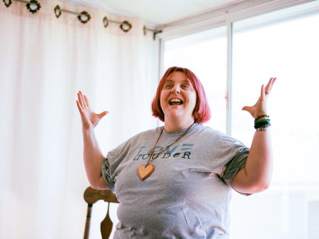 Direct care worker smiling and gesticulating with her hands.