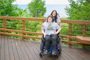 A woman in a wheelchair with her cargiver