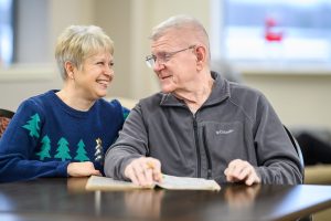 An elderly couple doing a word-find puzzle together