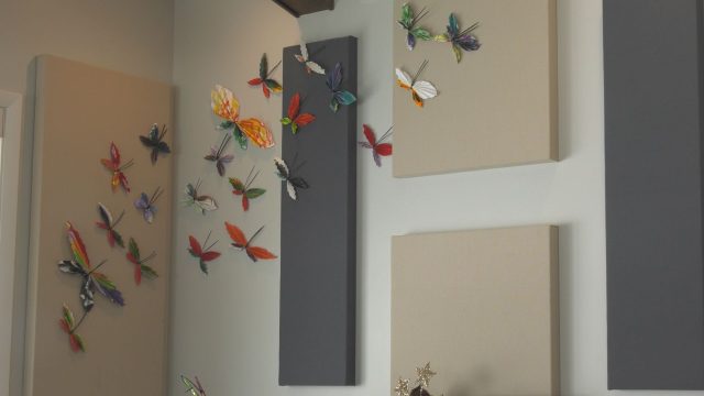 Paper butterflies being displayed on a wall