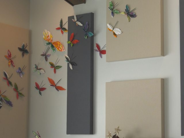 Paper butterflies being displayed on a wall